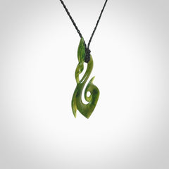 A beautiful jade manaia with koru pendant carved in New Zealand Jade. The pendant is suspended from a plaited black coloured cord. The cord is length adjustable so you can position the pendant where it suits you best. One only.