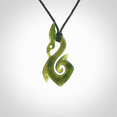 A beautiful jade manaia with koru pendant carved in New Zealand Jade. The pendant is suspended from a plaited black coloured cord. The cord is length adjustable so you can position the pendant where it suits you best. One only.