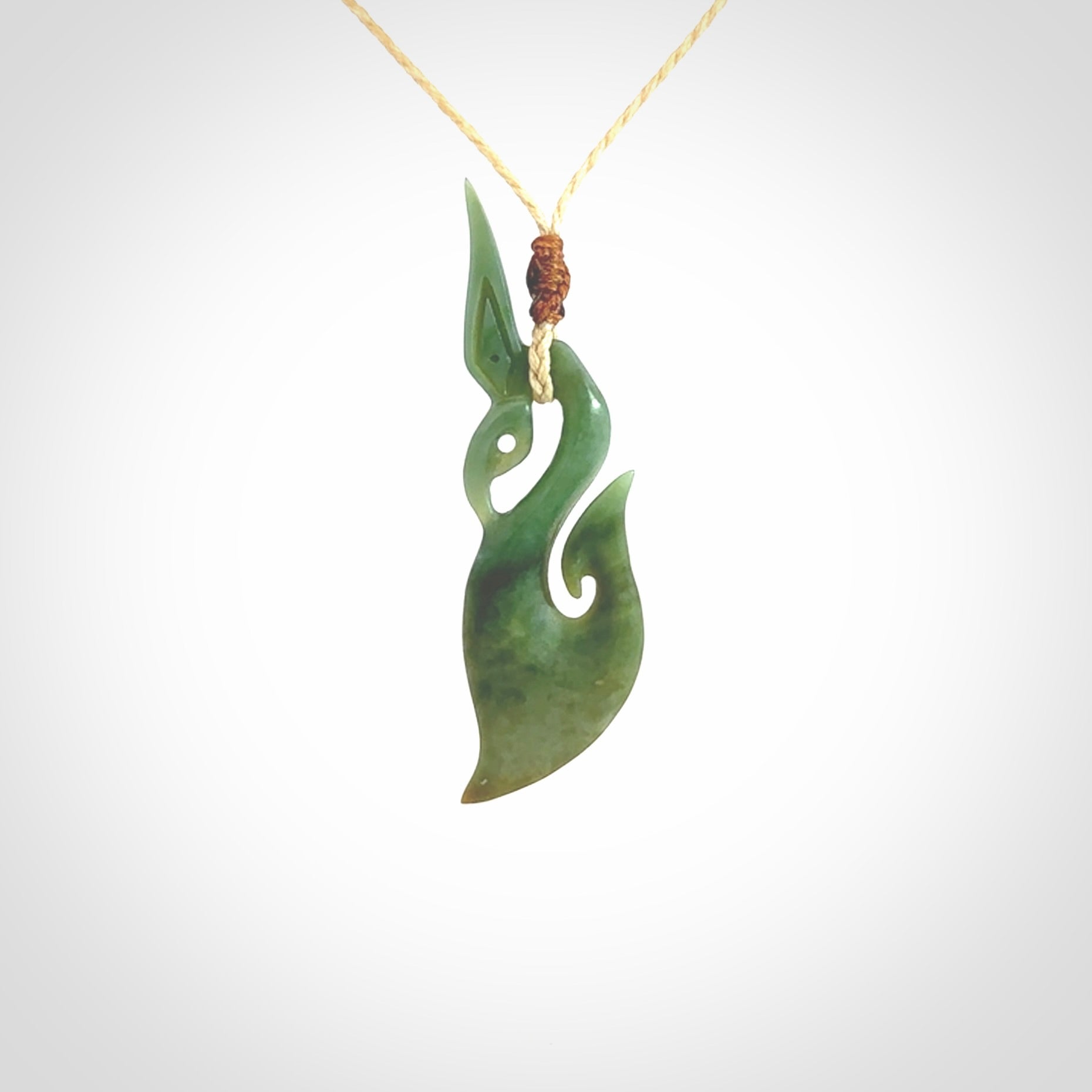 A hand carved New Zealand Jade manaia with hook pendant. Carved for us by Shaun Gardiner. One only medium sized Jade manaia necklace with adjustable cord.