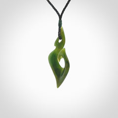 This photo shows a matau pendant carved from New Zealand Pounamu, Jade. The artist, Shaun Gardiner, has carved this beautifully. We provide this piece with an adjustable black coloured cord. This is a fantastic work of art, we have one only.