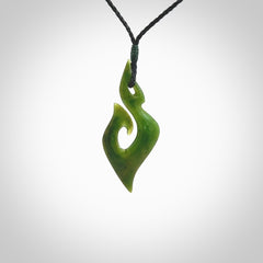 This photo shows a matau pendant carved from New Zealand Pounamu, Jade. The artist, Shaun Gardiner, has carved this beautifully. We provide this piece with an adjustable black coloured cord. This is a fantastic work of art, we have one only.