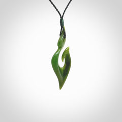 This photo shows a matau pendant carved from New Zealand Pounamu, Jade. The artist, Shaun Gardiner, has carved this beautifully. We provide this piece with an adjustable black coloured cord. This is a fantastic work of art, we have one only.