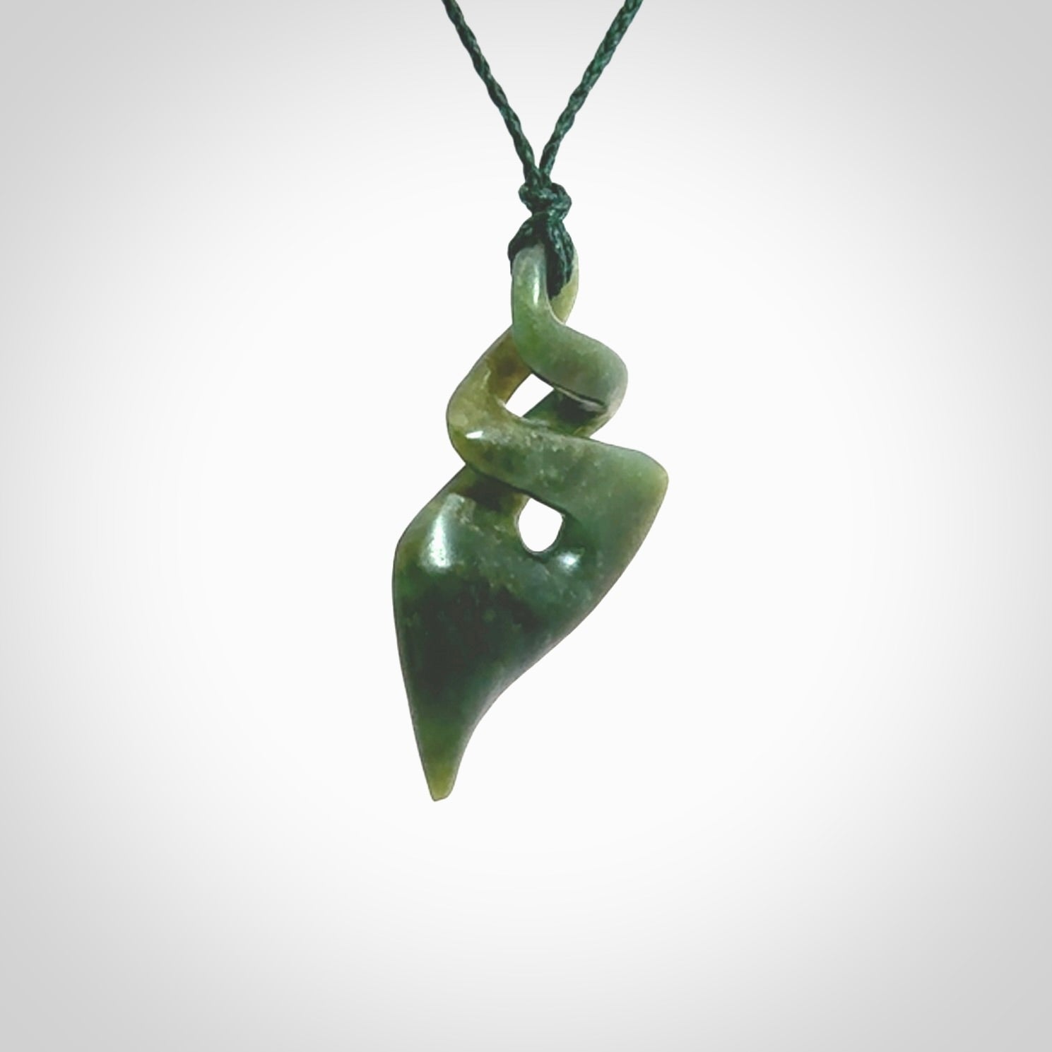 This is a striking, medium sized double twist pendant carved in New Zealand jade by Shaun Gardiner. Hand made Jade twist with adjustable green cord.