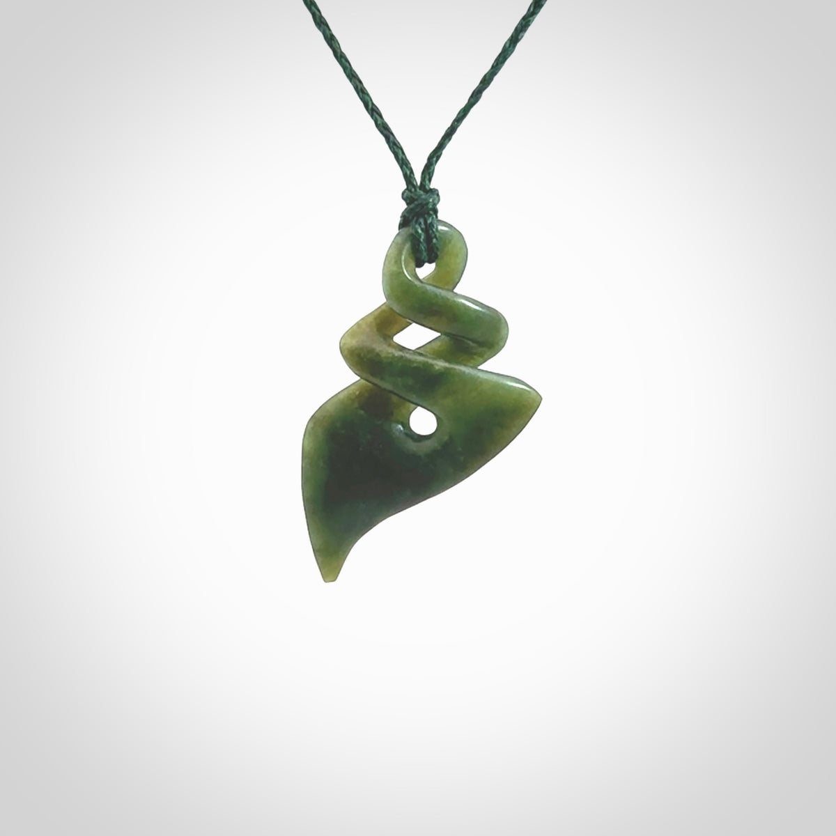 This is a striking, medium sized double twist pendant carved in New Zealand jade by Shaun Gardiner. Hand made Jade twist with adjustable green cord.