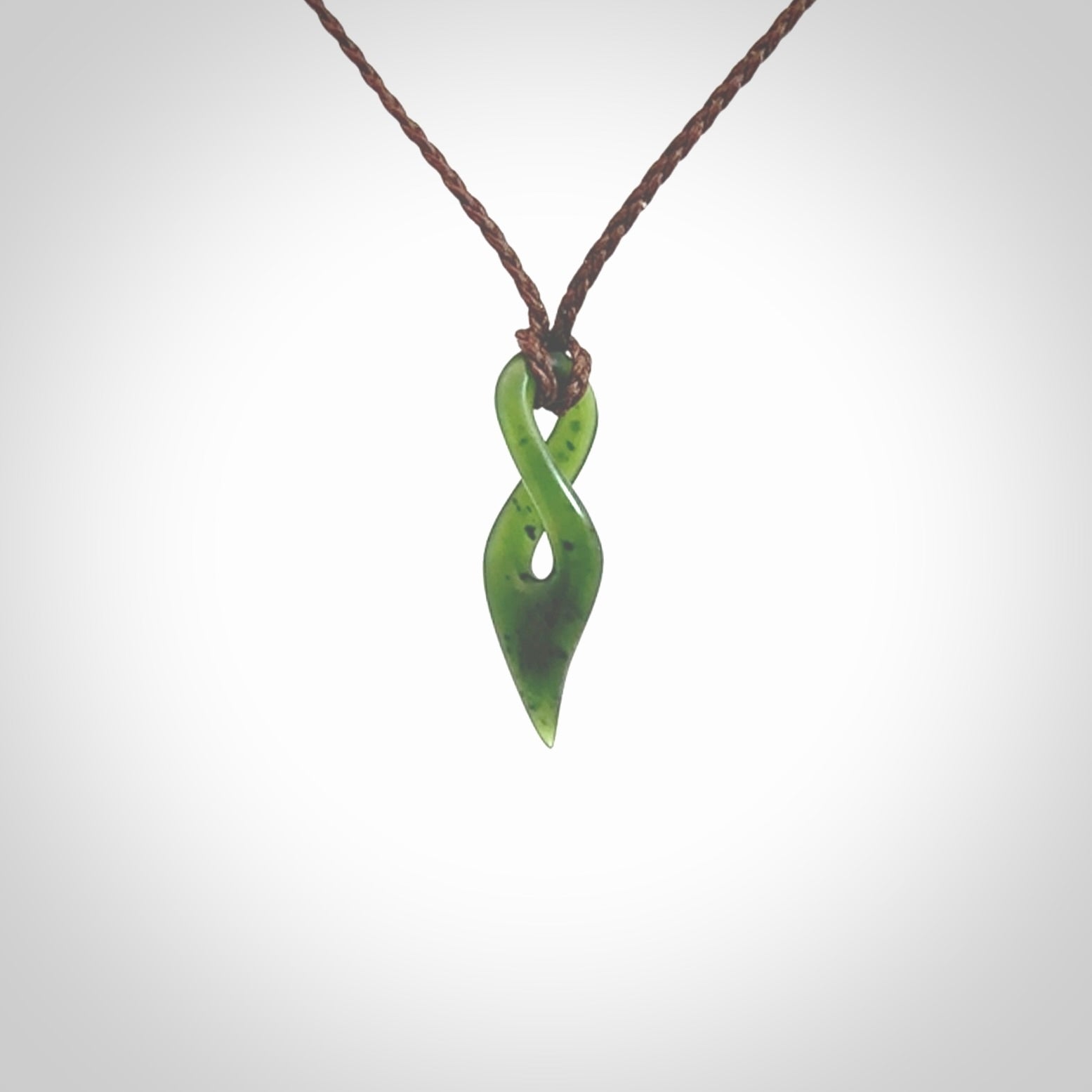 Hand carved medium sized, New Zealand jade twist pendant. Carved in New Zealand by NZ Pacific. Hand made small Jade twist with adjustable brown cord by Shaun Gardiner.