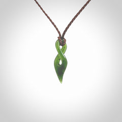 Hand carved medium sized, New Zealand jade twist pendant. Carved in New Zealand by NZ Pacific. Hand made small Jade twist with adjustable brown cord by Shaun Gardiner.