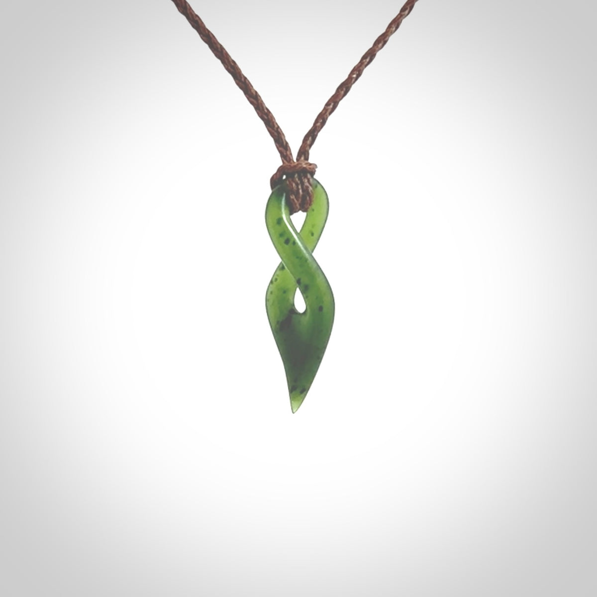 Hand carved medium sized, New Zealand jade twist pendant. Carved in New Zealand by NZ Pacific. Hand made small Jade twist with adjustable brown cord by Shaun Gardiner.