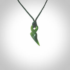 Hand carved small sized, New Zealand jade twist pendant. Carved in New Zealand by NZ Pacific. Hand made small Jade twist with adjustable manuka green cord by Shaun Gardiner.