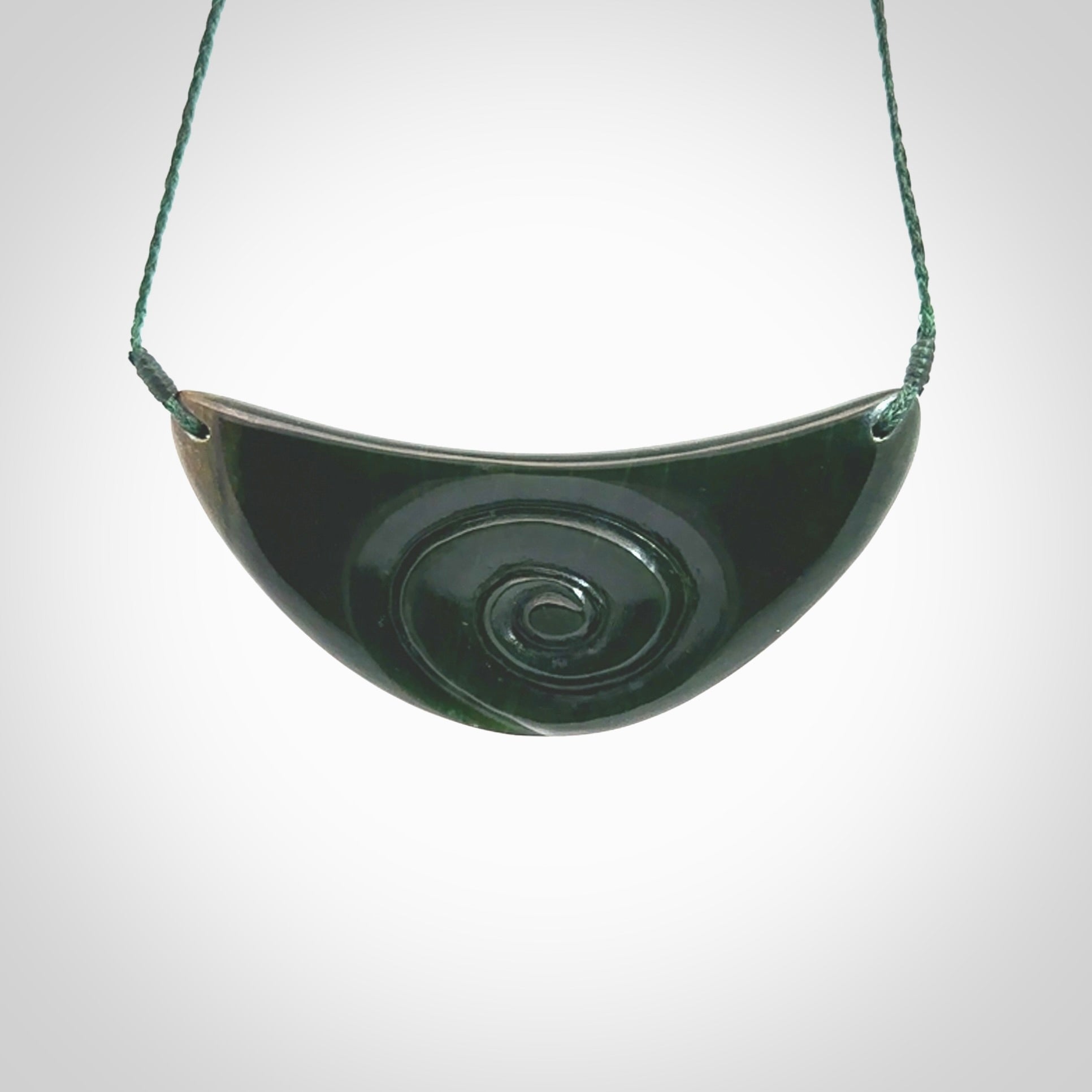 A gorgeous jade shield with koru pendant. Hand carved contemporary shield with Koru pendants for NZ Pacific. This is a stunning piece of art to wear. The jade is a New Zealand jade necklace with adjustable green cord.