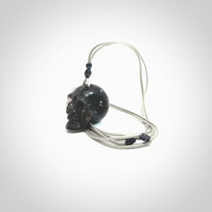 This picture shows a small sized Snowflake Obsidian stone skull pendant that we have hand carved. It is polished to a soft shine and is a very striking piece. Provided with an adjustable grey cord.