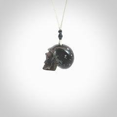 This picture shows a small sized Snowflake Obsidian stone skull pendant that we have hand carved. It is polished to a soft shine and is a very striking piece. Provided with an adjustable grey cord.