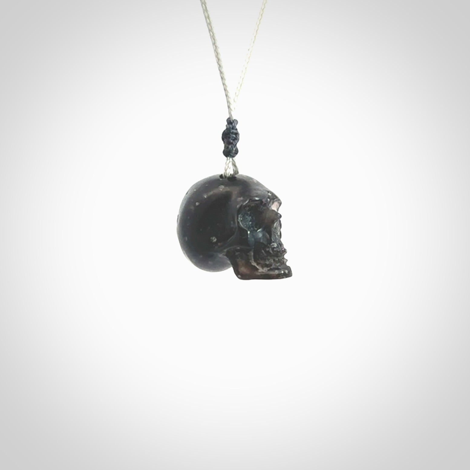 This picture shows a small sized Snowflake Obsidian stone skull pendant that we have hand carved. It is polished to a soft shine and is a very striking piece. Provided with an adjustable grey cord.