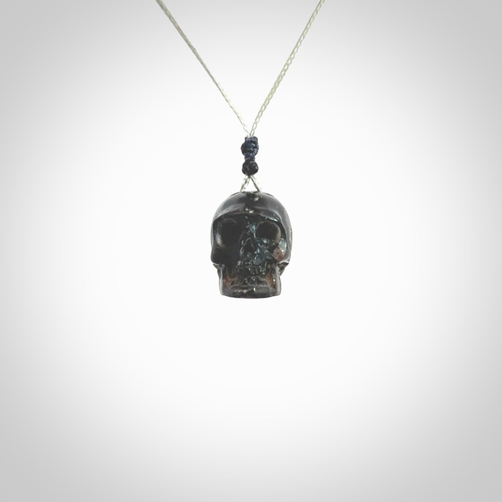 This picture shows a small sized Snowflake Obsidian stone skull pendant that we have hand carved. It is polished to a soft shine and is a very striking piece. Provided with an adjustable grey cord.