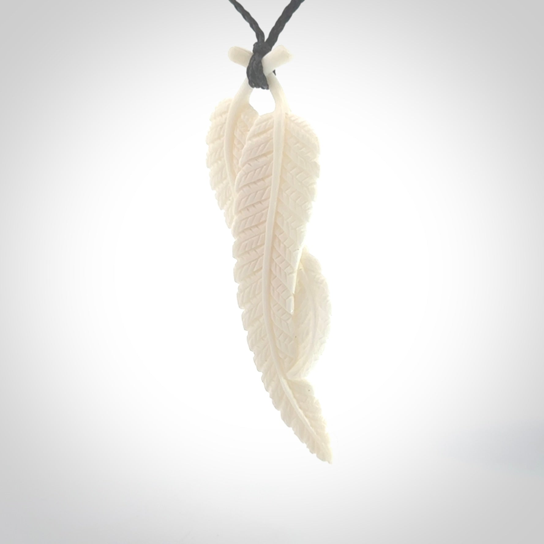 A hand carved large bone double fern leaf necklace. A beautiful large double fern leaf pendant carved from bone for NZ Pacific. This is a true piece of wearable art and is provided with an adjustable black cord.