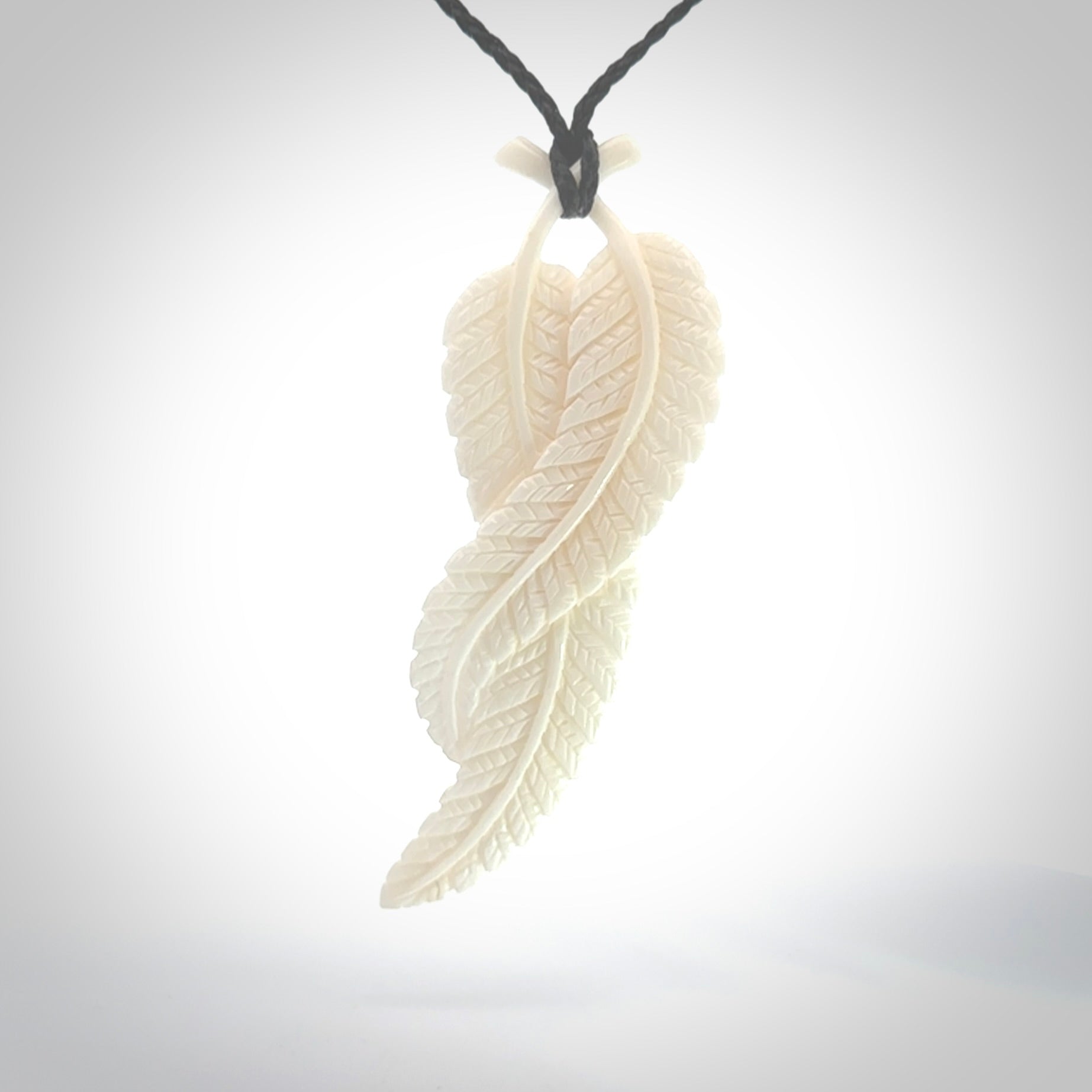 A hand carved large bone double fern leaf necklace. A beautiful large double fern leaf pendant carved from bone for NZ Pacific. This is a true piece of wearable art and is provided with an adjustable black cord.