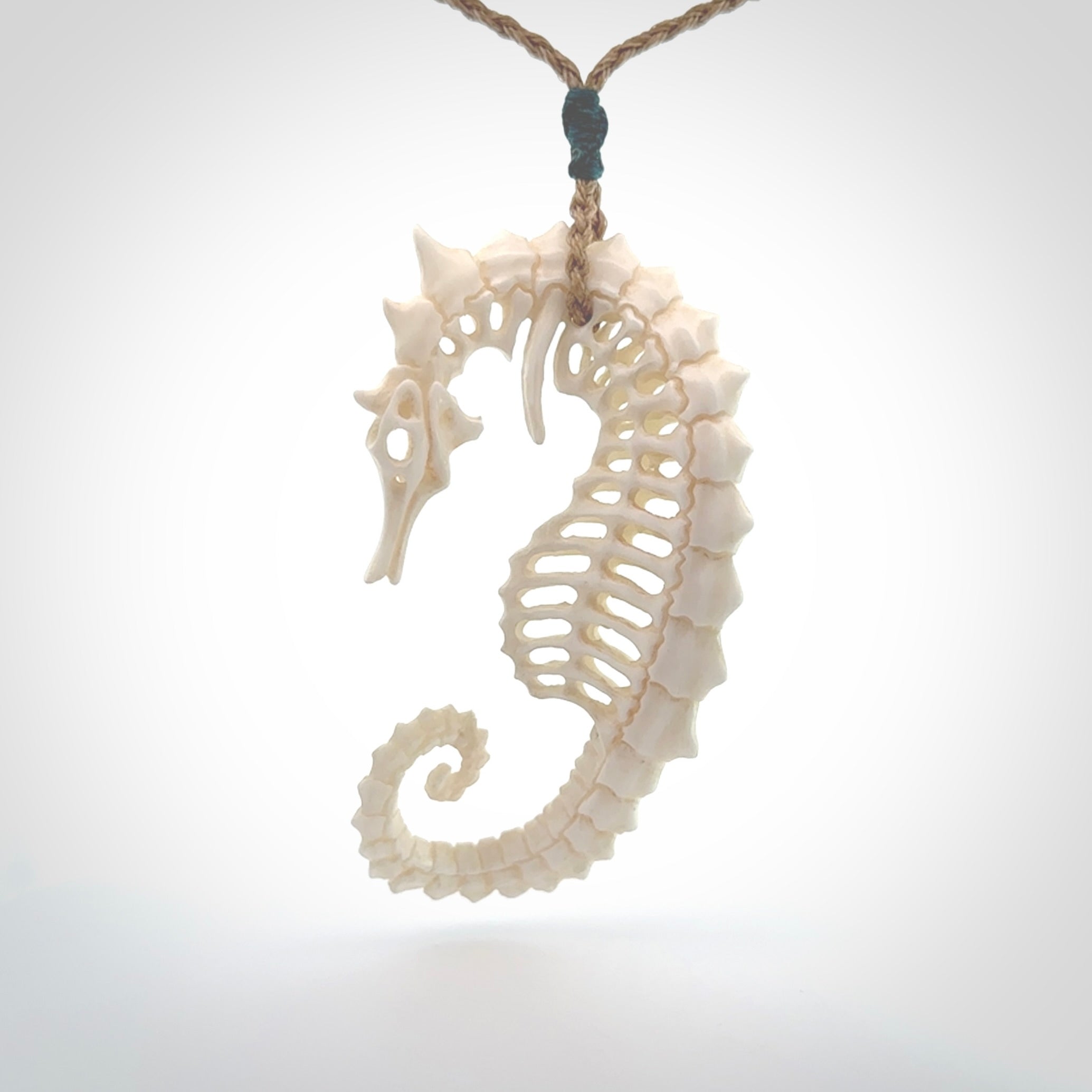 A hand carved intricate and complex seahorse skeleton pendant from bone. The cord is tan and adjustable in length. Large hand made seahorse skeleton necklace. One only.