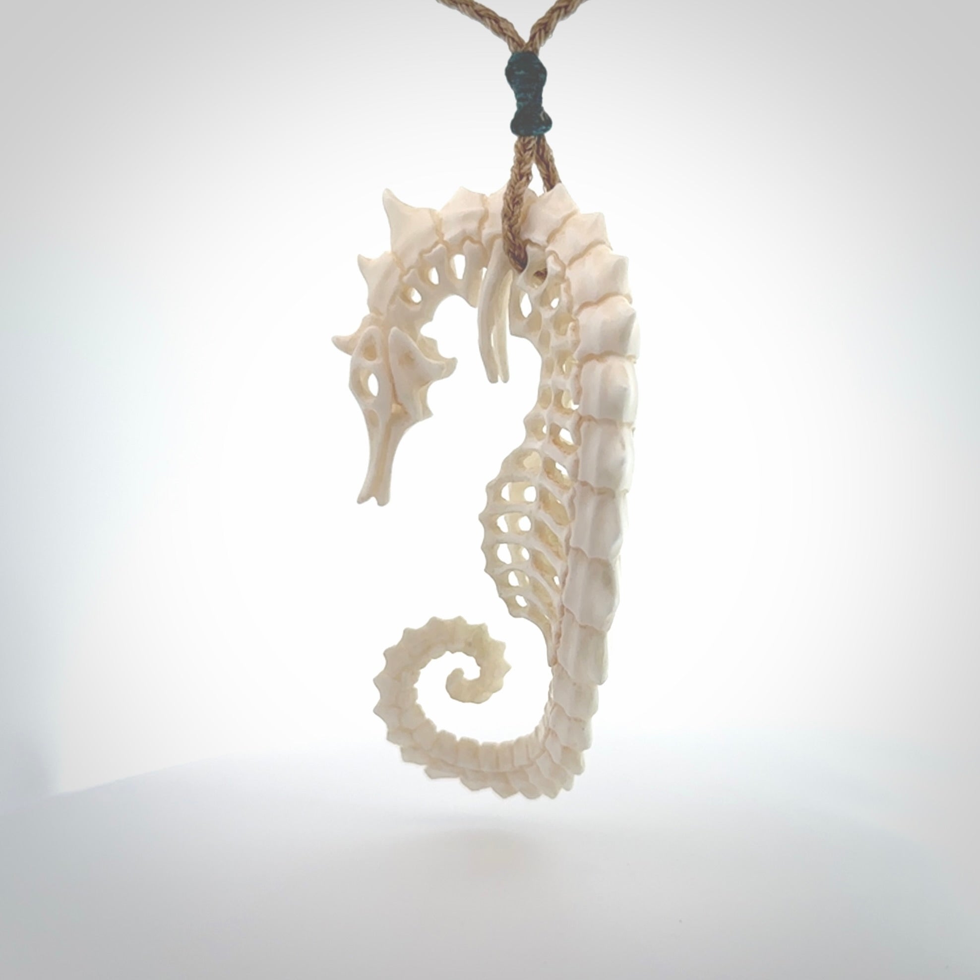 A hand carved intricate and complex seahorse skeleton pendant from bone. The cord is tan and adjustable in length. Large hand made seahorse skeleton necklace. One only.