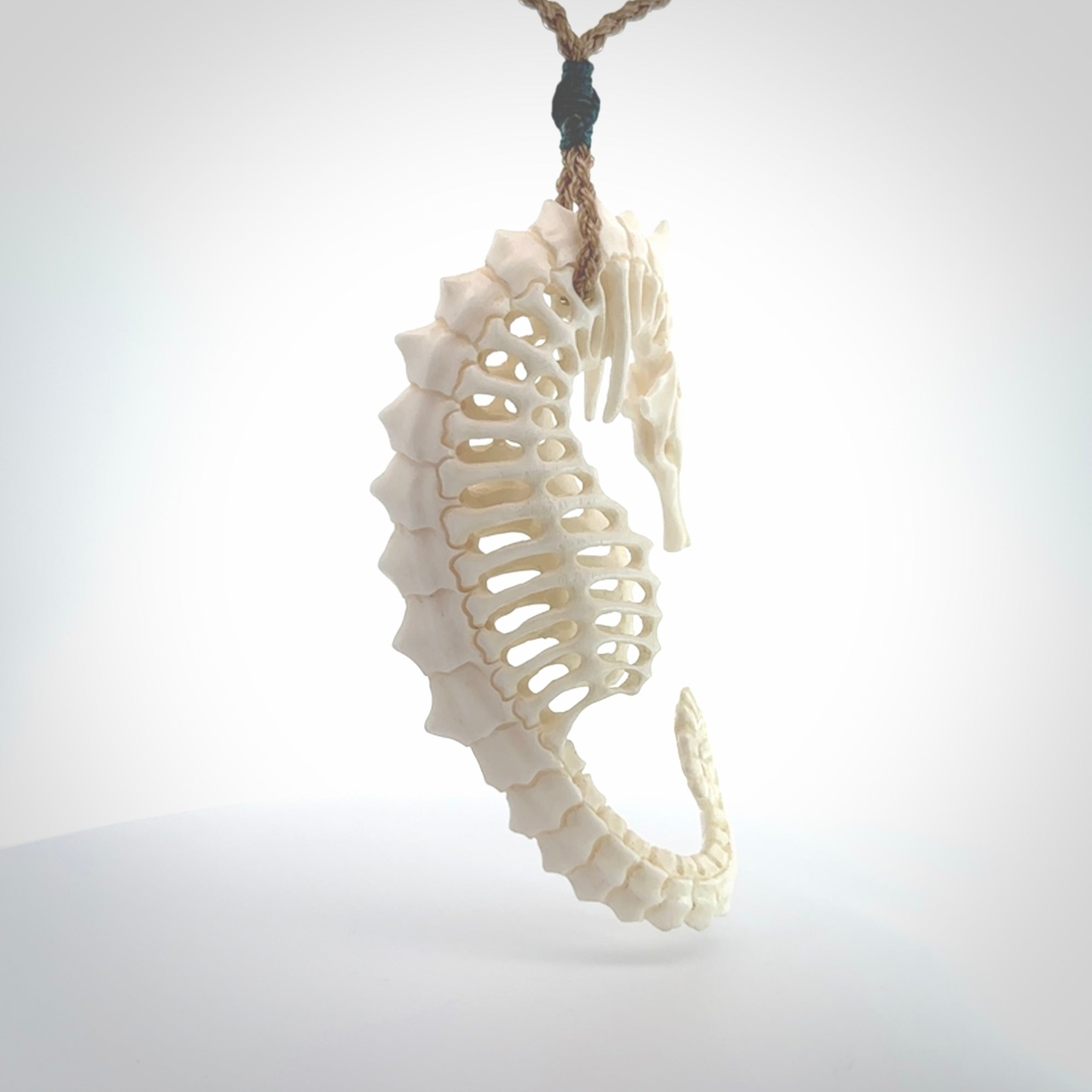 A hand carved intricate and complex seahorse skeleton pendant from bone. The cord is tan and adjustable in length. Large hand made seahorse skeleton necklace. One only.