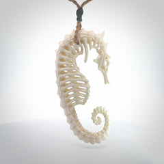 A hand carved intricate and complex seahorse skeleton pendant from bone. The cord is tan and adjustable in length. Large hand made seahorse skeleton necklace. One only.