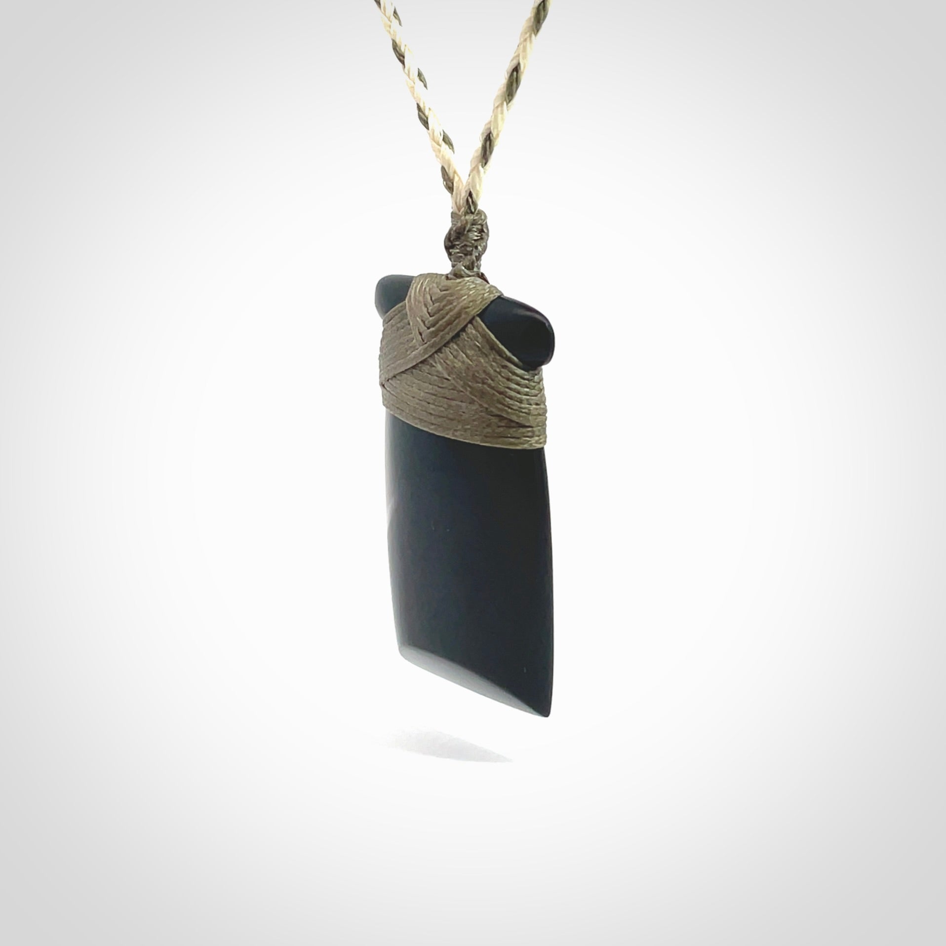 Hand carved black jade toki pendant. Made by NZ Pacific from Australian black jade. Black Jade Toki provided with adjustable cords and packaged in a woven kete pouch. Delivered with express courier.