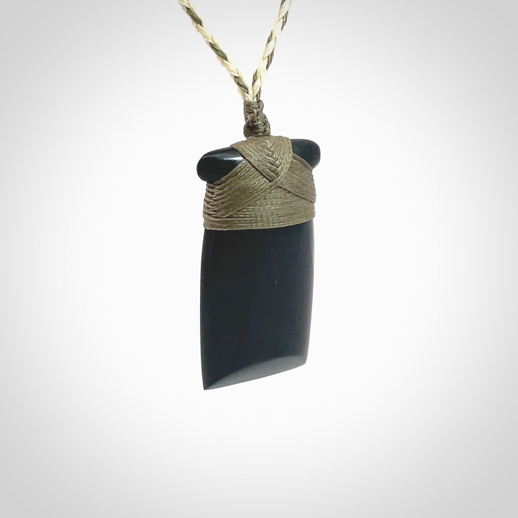 Hand carved black jade toki pendant. Made by NZ Pacific from Australian black jade. Black Jade Toki provided with adjustable cords and packaged in a woven kete pouch. Delivered with express courier.