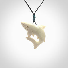 Hand carved shark pendant. Natural bone pendants from NZ Pacific. Provided with adjustable black cord and packaged in a woven kete pouch.