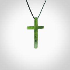 Hand carved jade cross. Made from New Zealand jade. Christian cross for sale online.This picture shows a green jade cross suspended on a fine, plaited cord. The cross is hand carved jade cross. Made from New Zealand jade. Christian cross for sale online.