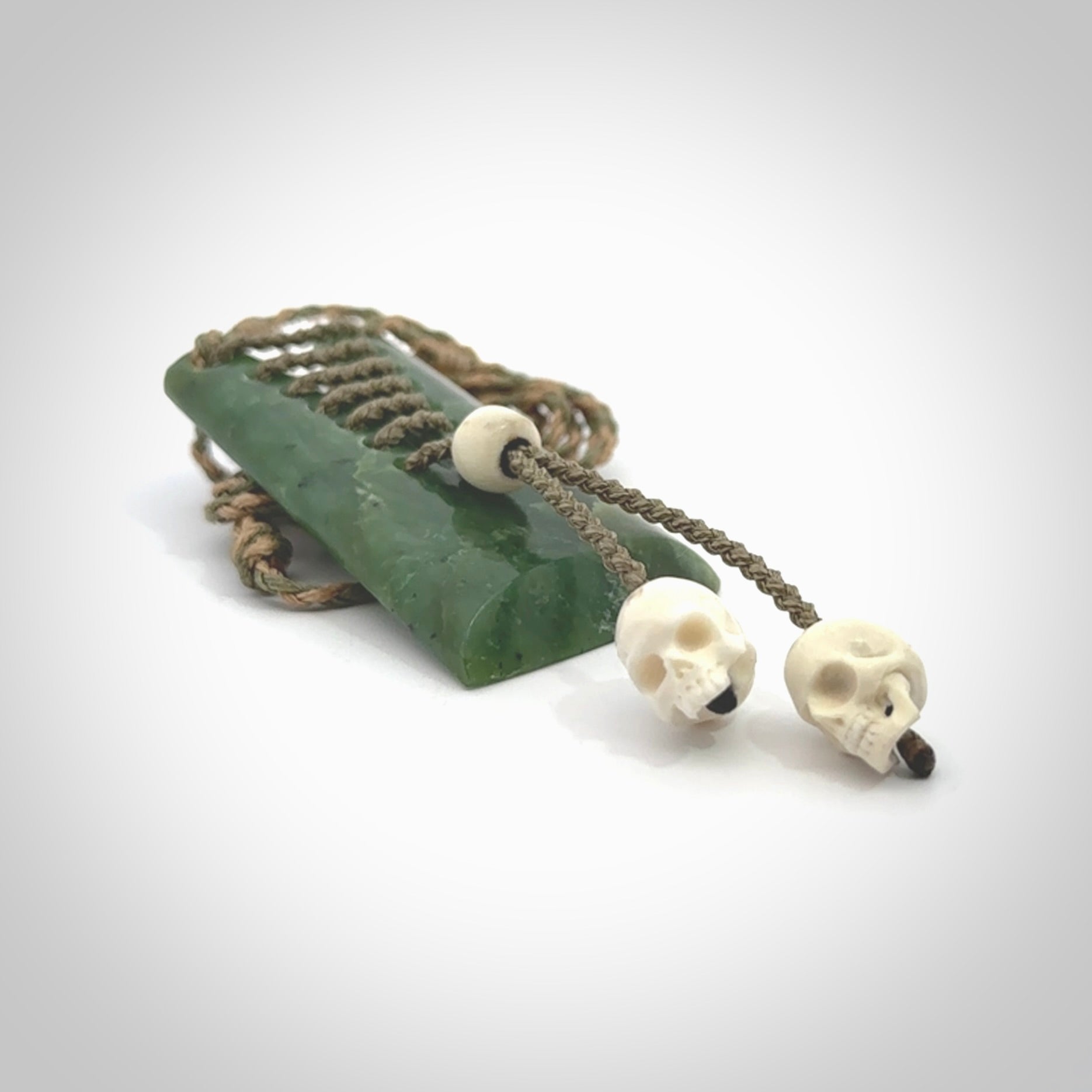 This pendant is a daily reminder of mortality. A Jade toki pendant with two bone skulls. Hand carved Jade and Bone art to wear. One only.