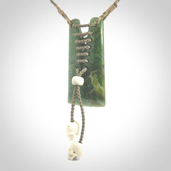 This pendant is a daily reminder of mortality. A Jade toki pendant with two bone skulls. Hand carved Jade and Bone art to wear. One only.