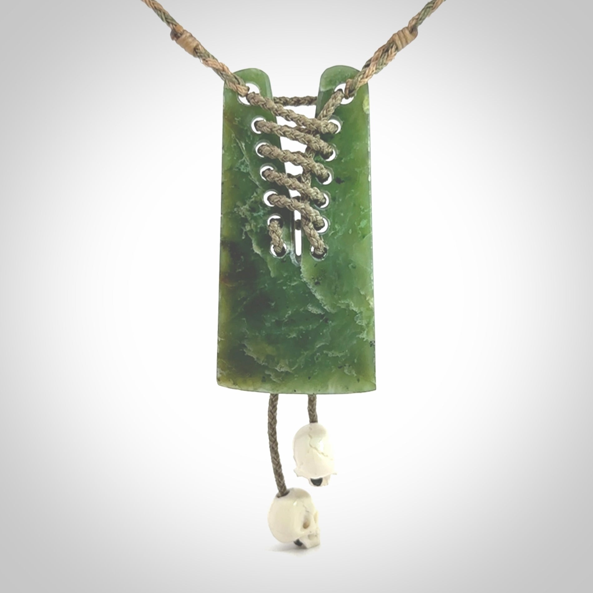 This pendant is a daily reminder of mortality. A Jade toki pendant with two bone skulls. Hand carved Jade and Bone art to wear. One only.