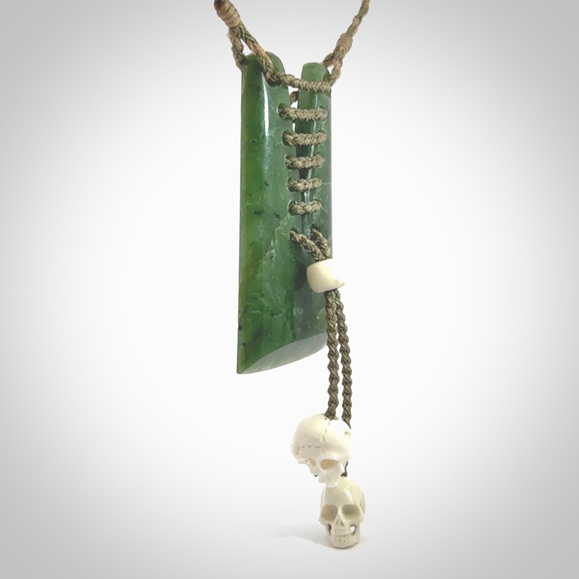 This pendant is a daily reminder of mortality. A Jade toki pendant with two bone skulls. Hand carved Jade and Bone art to wear. One only.