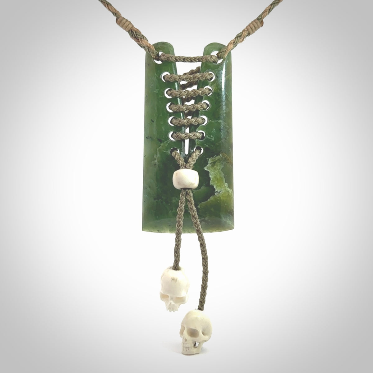 This pendant is a daily reminder of mortality. A Jade toki pendant with two bone skulls. Hand carved Jade and Bone art to wear. One only.