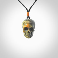 This picture shows a medium sized Bumblebee Jasper stone skull pendant that we have hand carved. It is polished to a soft shine and is a very striking piece. The cord is black colour and has a small orange popper binding just above the pendant.