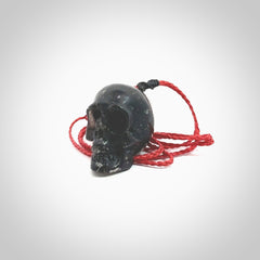 This picture shows a large sized Snowflake Obsidian stone skull pendant that we have hand carved. It is polished to a soft shine and is a very striking piece. Provided with an adjustable red cord.