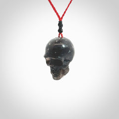 This picture shows a large sized Snowflake Obsidian stone skull pendant that we have hand carved. It is polished to a soft shine and is a very striking piece. Provided with an adjustable red cord.