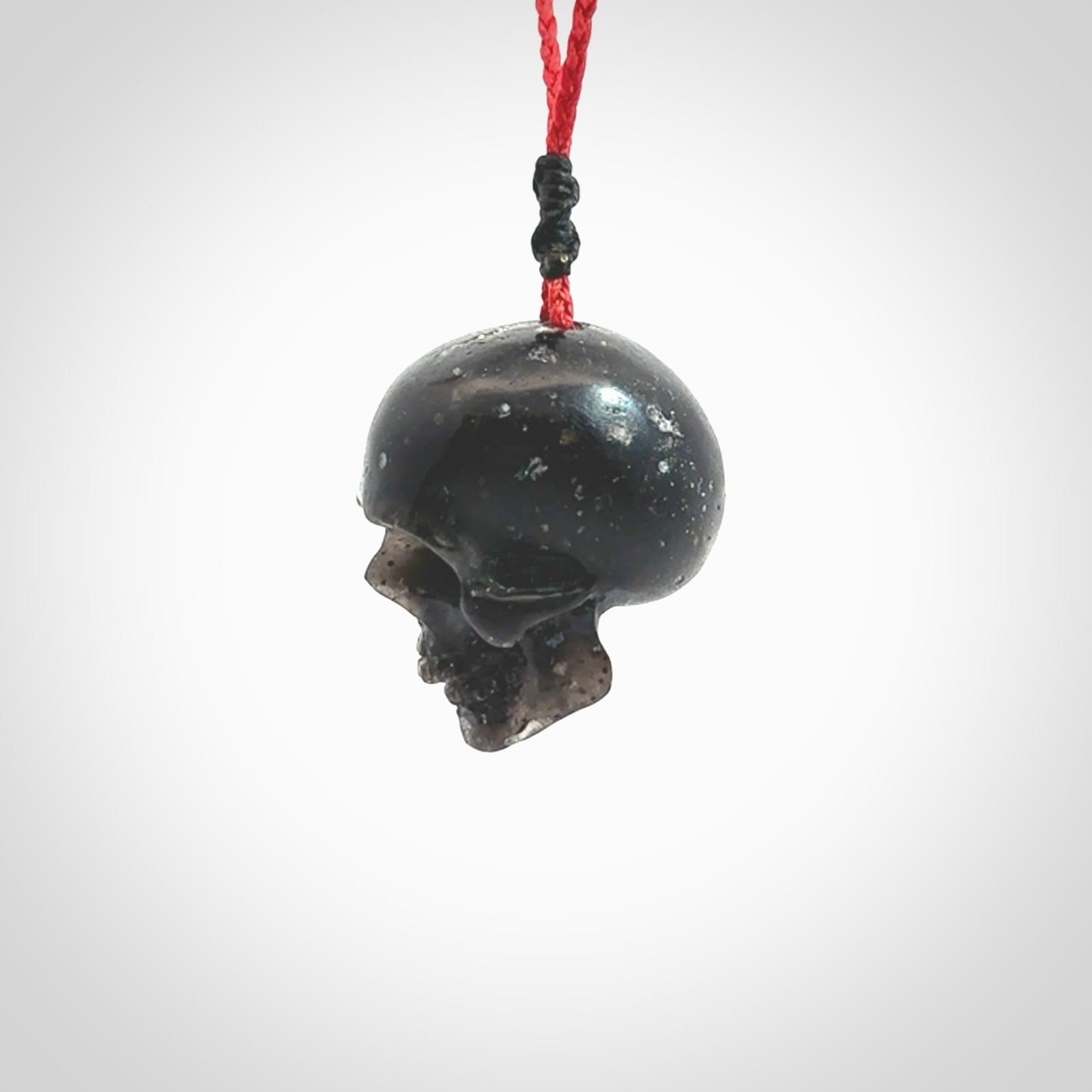 This picture shows a large sized Snowflake Obsidian stone skull pendant that we have hand carved. It is polished to a soft shine and is a very striking piece. Provided with an adjustable red cord.