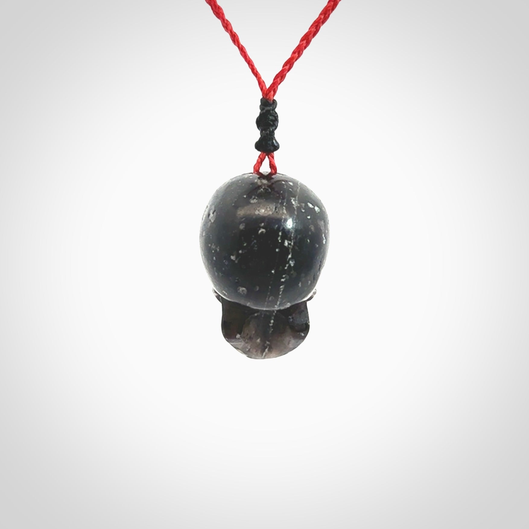 This picture shows a large sized Snowflake Obsidian stone skull pendant that we have hand carved. It is polished to a soft shine and is a very striking piece. Provided with an adjustable red cord.