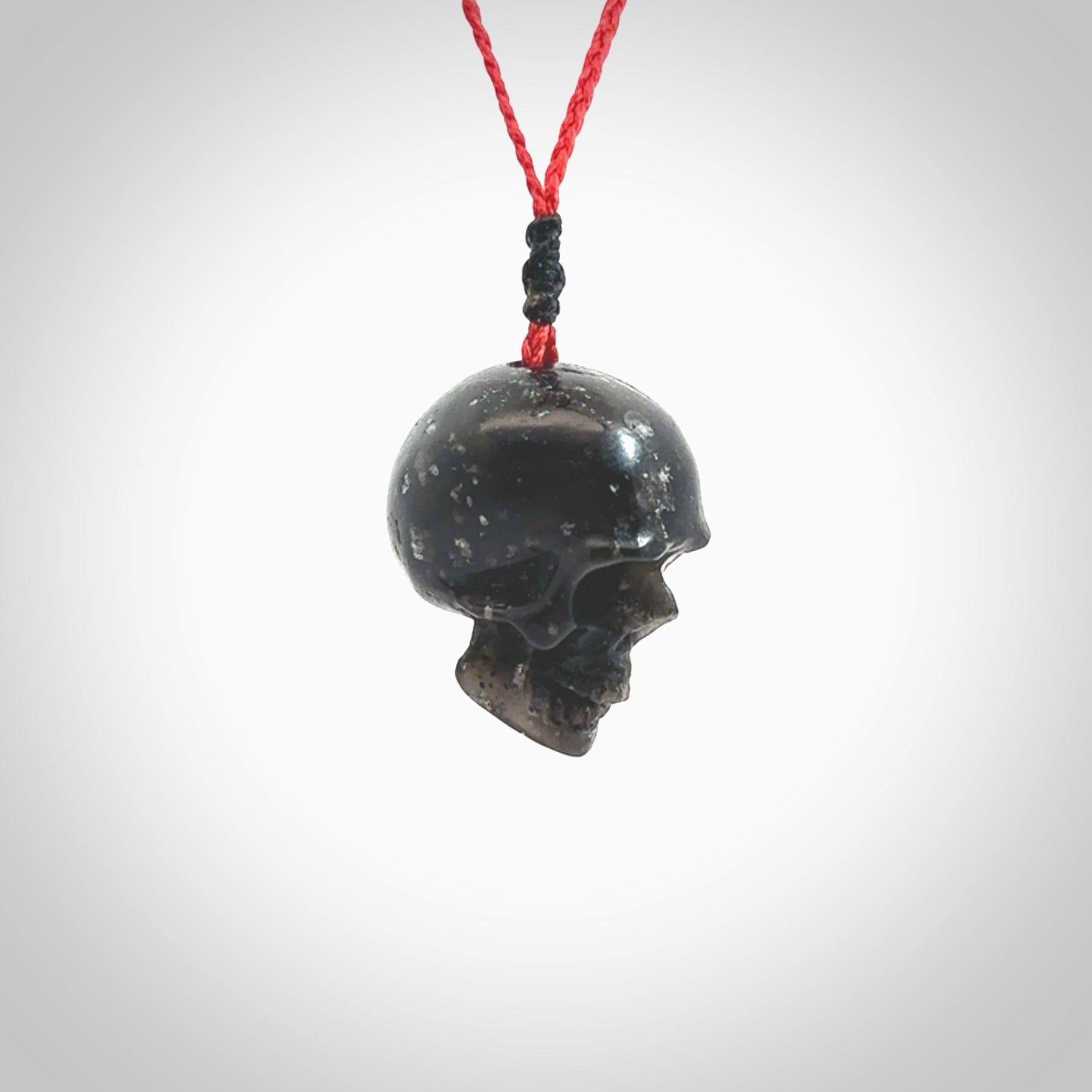 This picture shows a large sized Snowflake Obsidian stone skull pendant that we have hand carved. It is polished to a soft shine and is a very striking piece. Provided with an adjustable red cord.