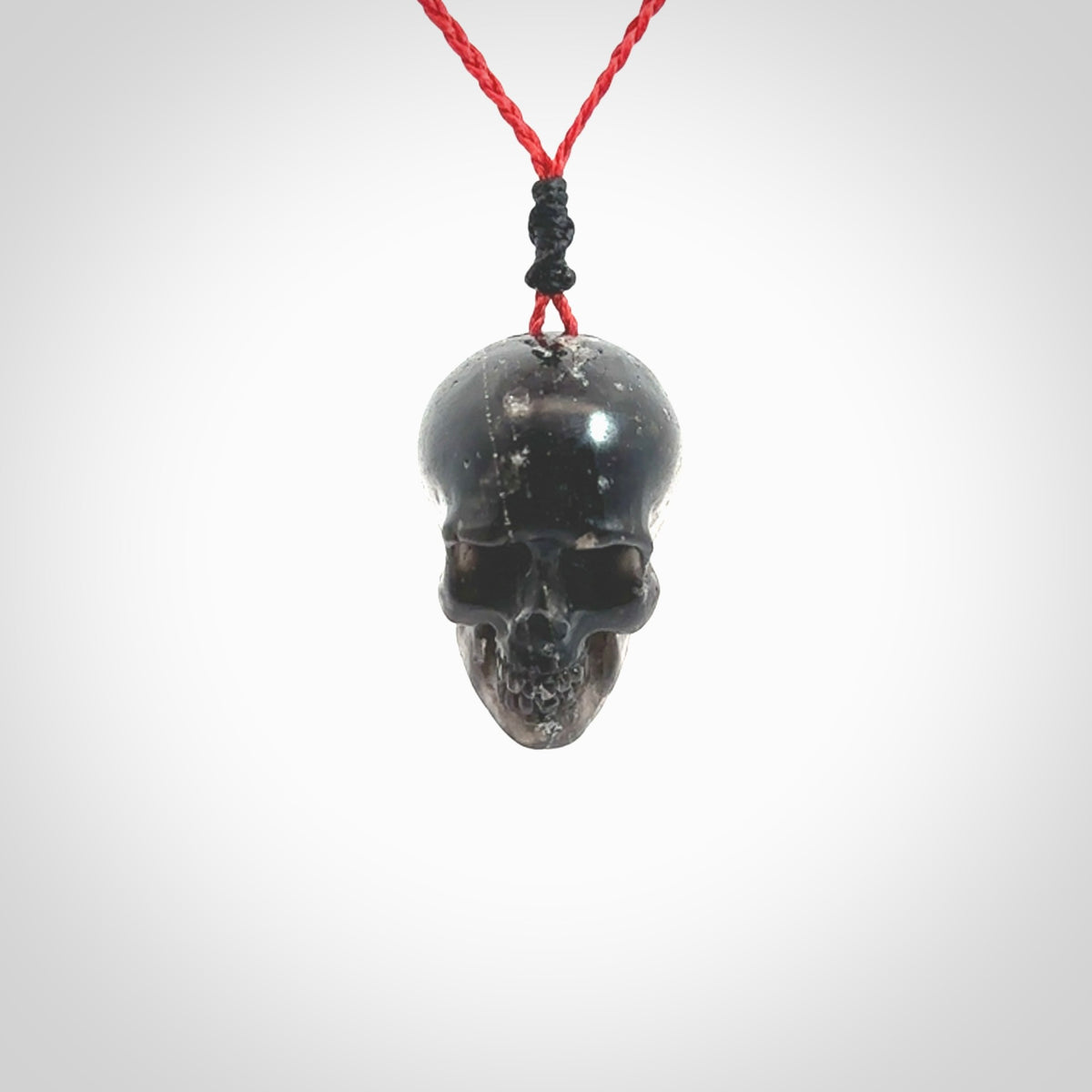 This picture shows a large sized Snowflake Obsidian stone skull pendant that we have hand carved. It is polished to a soft shine and is a very striking piece. Provided with an adjustable red cord.