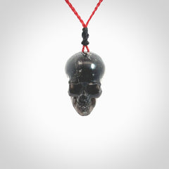 This picture shows a large sized Snowflake Obsidian stone skull pendant that we have hand carved. It is polished to a soft shine and is a very striking piece. Provided with an adjustable red cord.