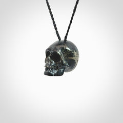 This picture shows a medium sized Snowflake Obsidian stone skull pendant that we have hand carved. It is polished to a soft shine and is a very striking piece. Provided with an adjustable black cord.