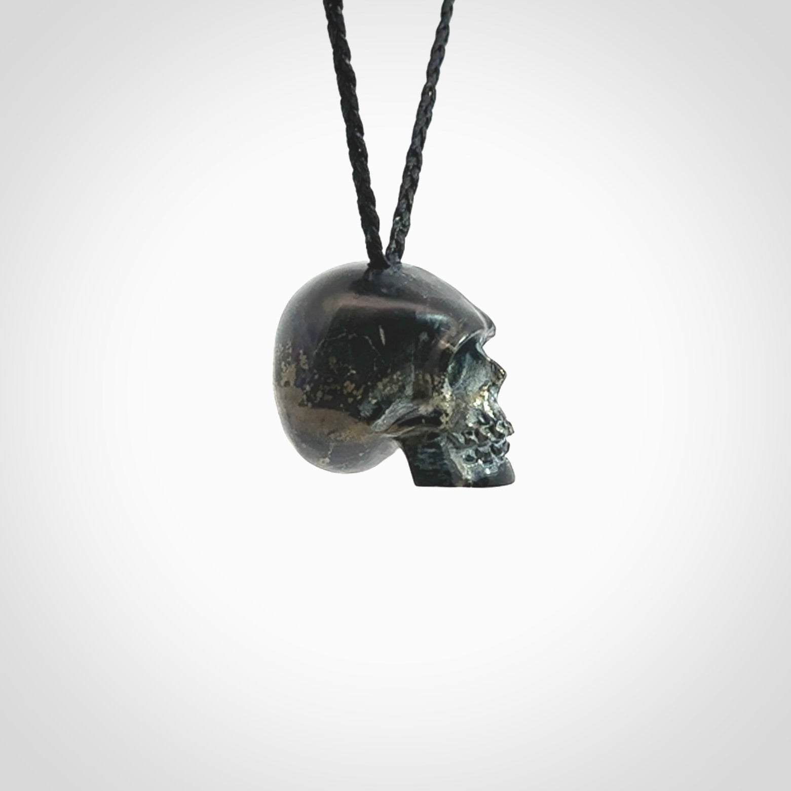 This picture shows a medium sized Snowflake Obsidian stone skull pendant that we have hand carved. It is polished to a soft shine and is a very striking piece. Provided with an adjustable black cord.