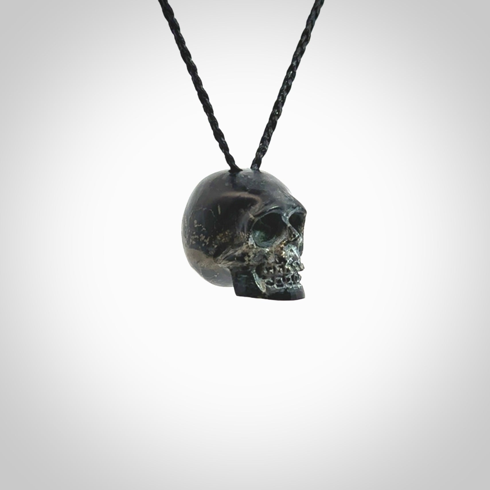 This picture shows a medium sized Snowflake Obsidian stone skull pendant that we have hand carved. It is polished to a soft shine and is a very striking piece. Provided with an adjustable black cord.