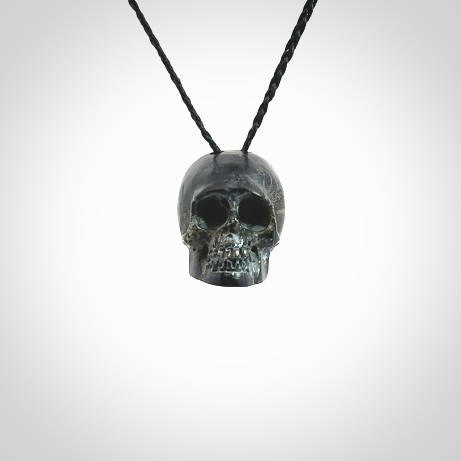 This picture shows a medium sized Snowflake Obsidian stone skull pendant that we have hand carved. It is polished to a soft shine and is a very striking piece. Provided with an adjustable black cord.