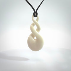 These are very cool, simple double twist pendants carved from natural bone. We have bound these in a black cord and will ship them to you wherever you are. Hand carved by NZ Pacific.