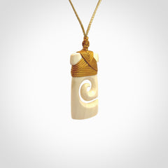 Hand carved Woolly Mammoth Tusk toki with koru pendant. Toki with koru necklace carved from ancient woolly mammoth tusk. Provided with adjustable cord and packaged in a woven kete pouch.