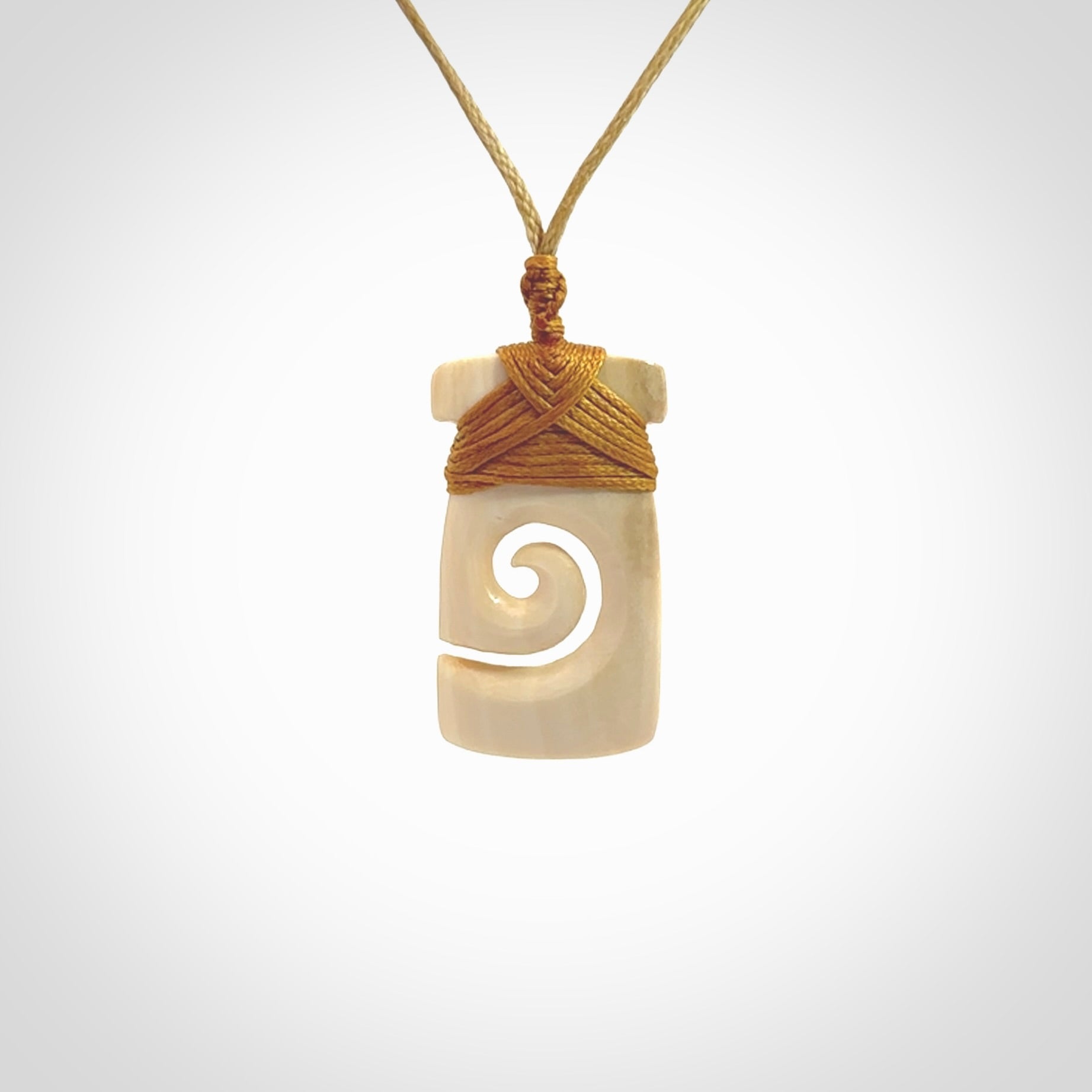 Hand carved Woolly Mammoth Tusk toki with koru pendant. Toki with koru necklace carved from ancient woolly mammoth tusk. Provided with adjustable cord and packaged in a woven kete pouch.