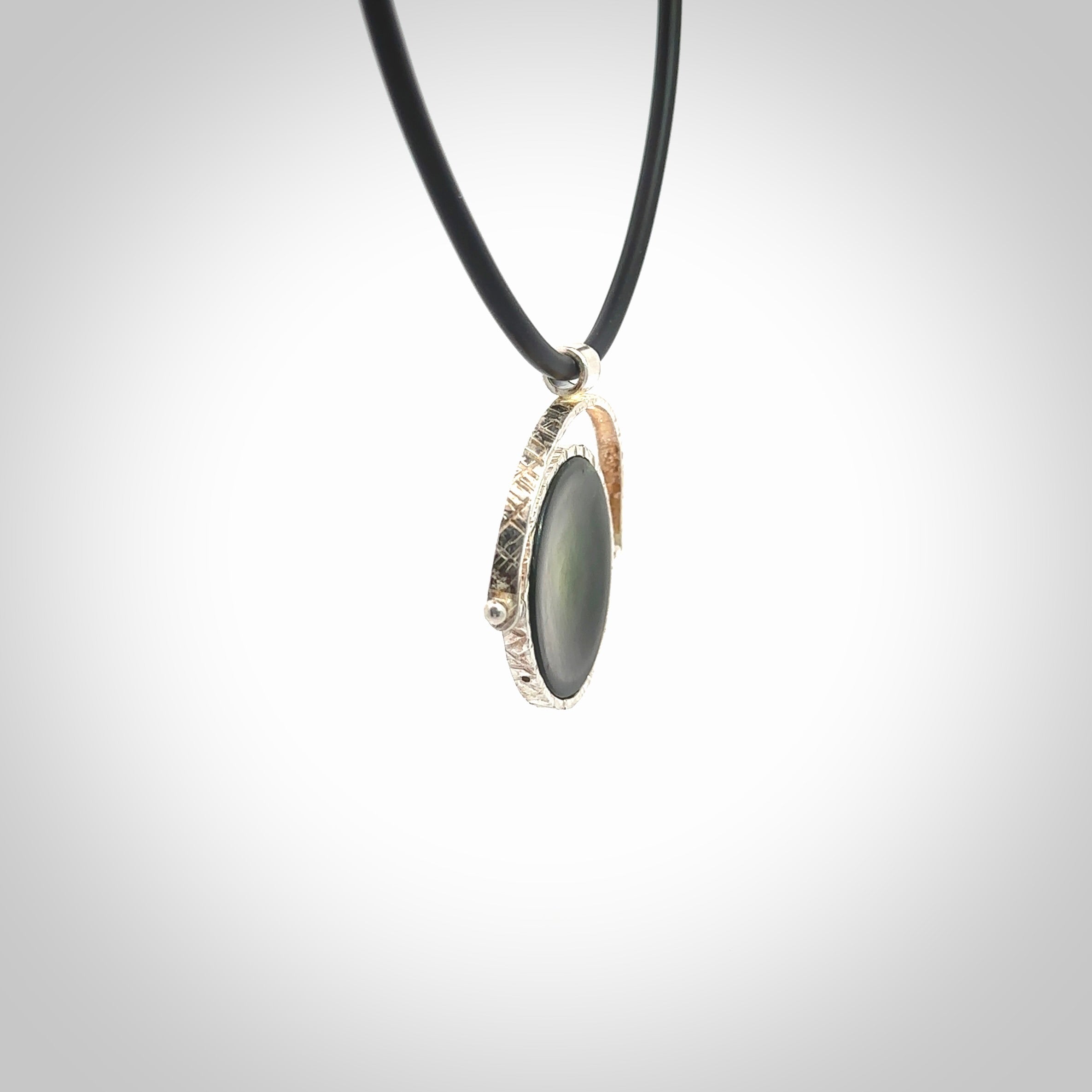 A photo of a New Zealand Jade drop pendant with sterling silver. This is a stylish statement piece - hand crafted here in New Zealand by Ana Krakosky. Unique Art to Wear. Gifts for all lovers of hand made Art to Wear. One only Fidget pendant.