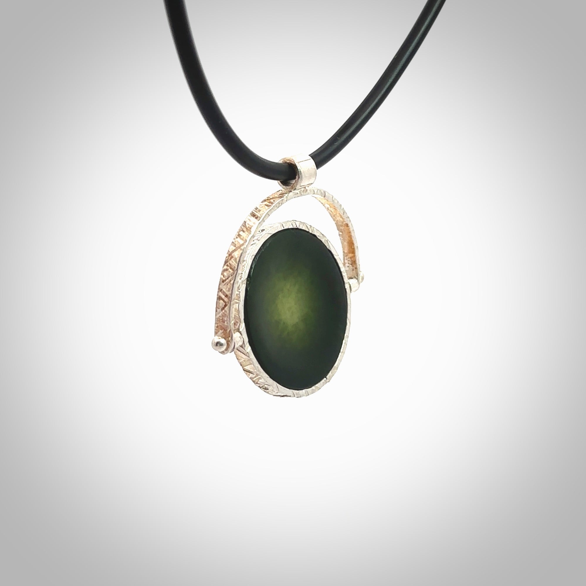 A photo of a New Zealand Jade drop pendant with sterling silver. This is a stylish statement piece - hand crafted here in New Zealand by Ana Krakosky. Unique Art to Wear. Gifts for all lovers of hand made Art to Wear. One only Fidget pendant.