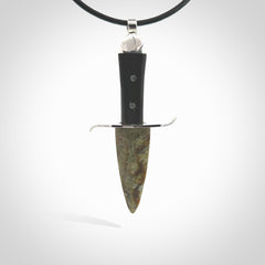 A striking hand carved knife pendant. These are carved with a green jade head and a hardwood handle. The necklace is made of leather and has a clasp fixture. We ship these worldwide with express courier.